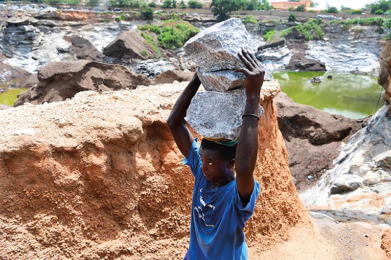 Youngster carrying granite