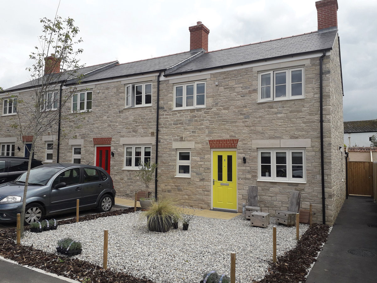 Purbeck white buff stone was used to create modern terraced housing in Bridport in a way that blends in with the local vernacular Purbeck white buff stone used in modern terraced housing