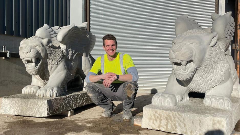 Ryan outside his workshop at Traditional Stone with the two completed griffins